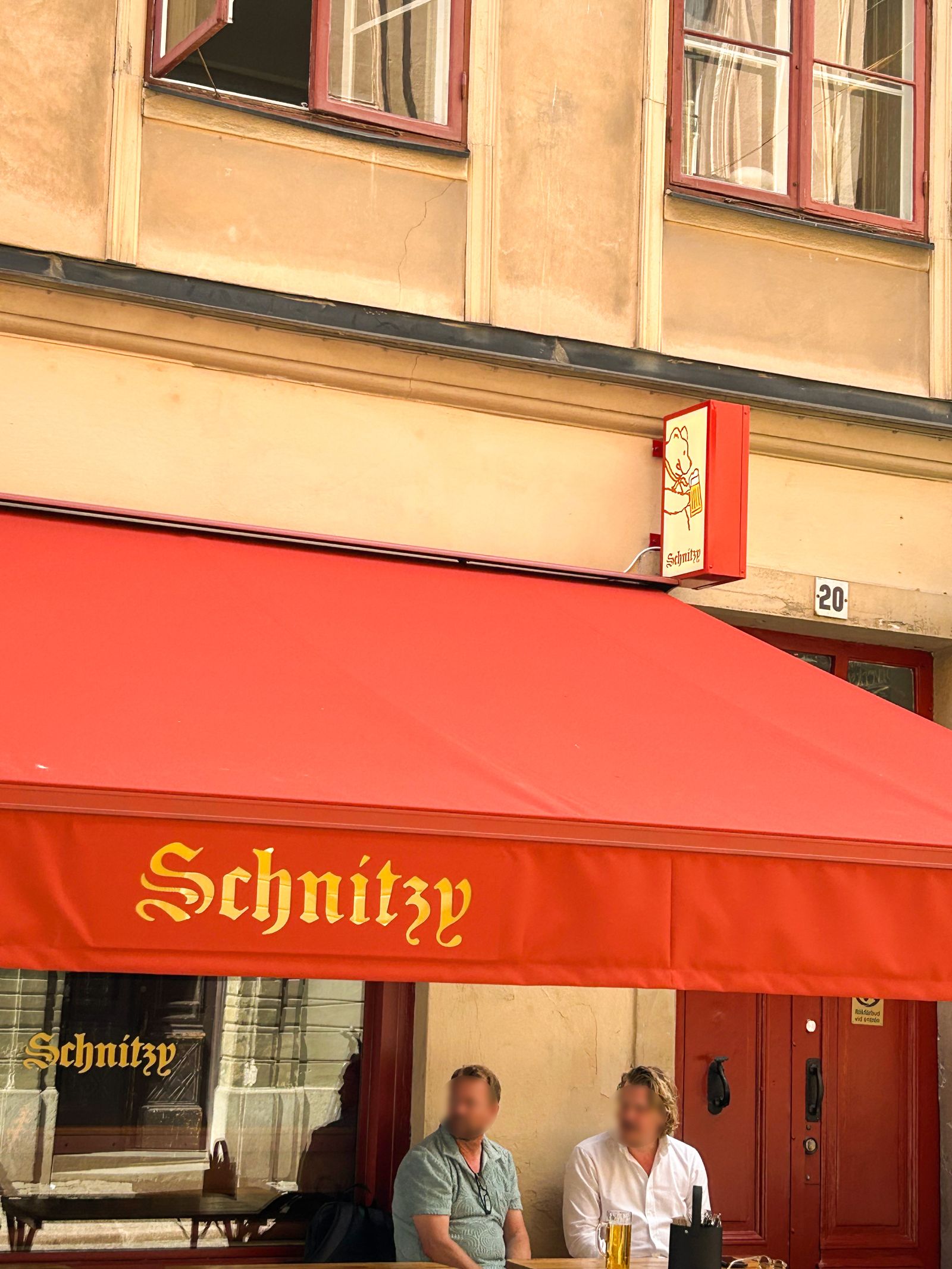 Terrassmarkis med LED-belyst logotyp över Schnitzys uteservering